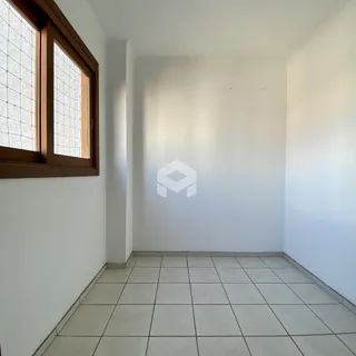 Interior de uma sala com piso de cerâmica e paredes brancas.