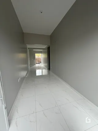 Corredor interno de uma residência com piso de mármore branco.