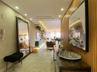 Interior de uma sala de estar com painéis de madeira e espelho grande.