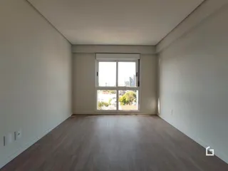 A sala apresenta paredes brancas e piso de madeira clara.
