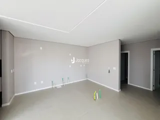 Ambiente interno de uma sala ampla com paredes cinzas.