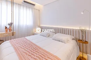 Foto de um quarto com cama grande e cortinas brancas.