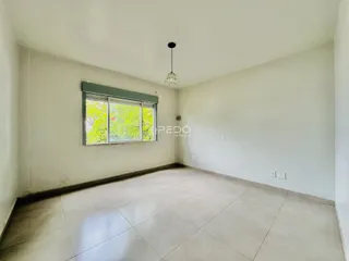 Ambiente interno de uma sala com piso de cerâmica e janela.