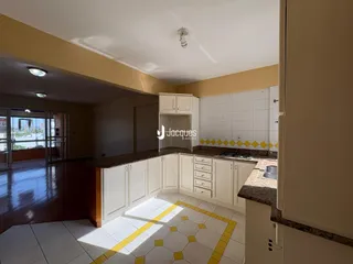 Cozinha com armários brancos e piso em ladrilhos amarelos e brancos.