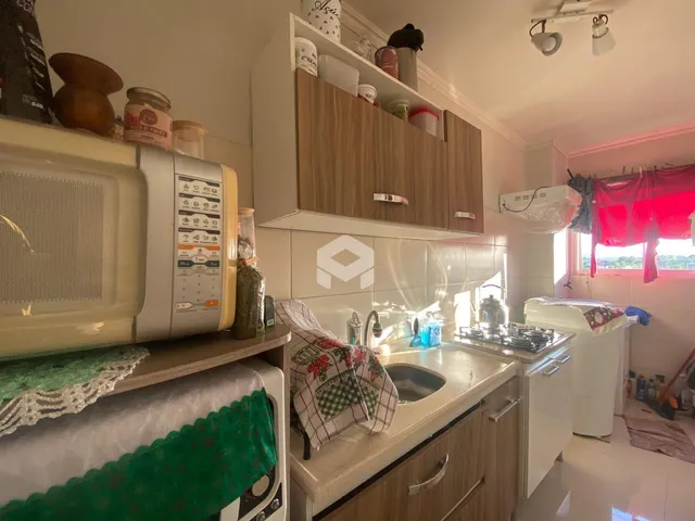 Cozinha com armários de madeira e bancada branca.