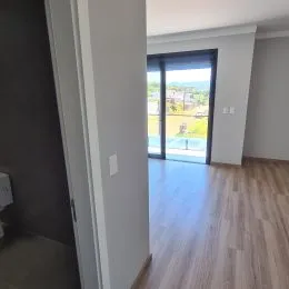 Vista interna de um corredor com piso de madeira clara.