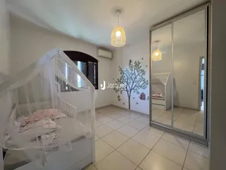 Foto de um quarto com cama e armário de espelho em um imóvel.