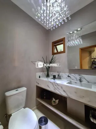 Foto de um banheiro com bancada de mármore e vaso sanitário branco.