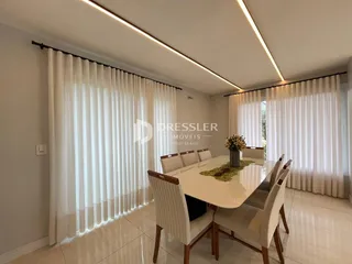 Sala de jantar com mesa e cadeiras em um ambiente claro.