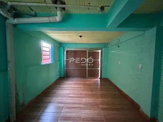 Corredor interno de uma residência com piso de cerâmica marrom.