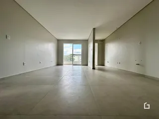 Vista ampla de uma sala de estar com piso de concreto e paredes brancas.