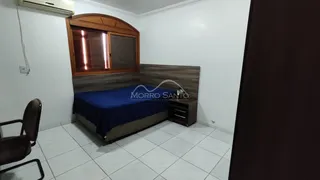 Quarto com cama e cabeceira de madeira em um ambiente claro.