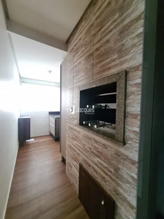 Hall de entrada com piso de madeira e parede texturizada.