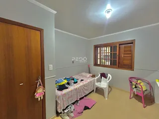 Quarto interno com cama e porta de madeira em imóvel no Brasil.