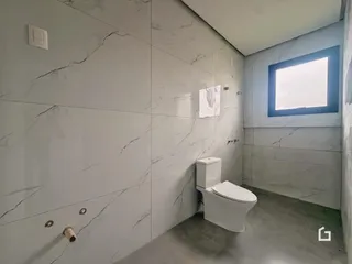 Banheiro com paredes revestidas em mármore cinza e branco.