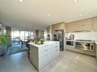 Cozinha moderna com ilha e portas de vidro de acesso ao exterior.