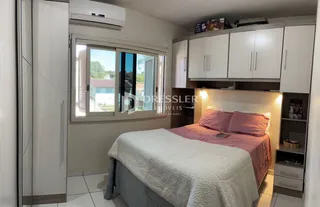Quarto com cama e armários brancos em um imóvel no Brasil.