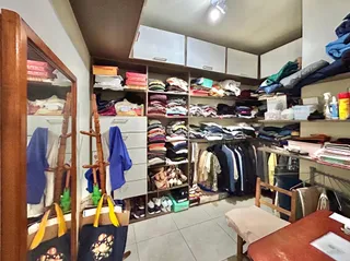 Quarto com armários e estantes cheios de roupas em Lajeado, Brasil.