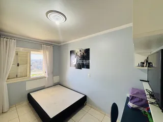 Quarto com janela e parede azul claro em um imóvel no Brasil.