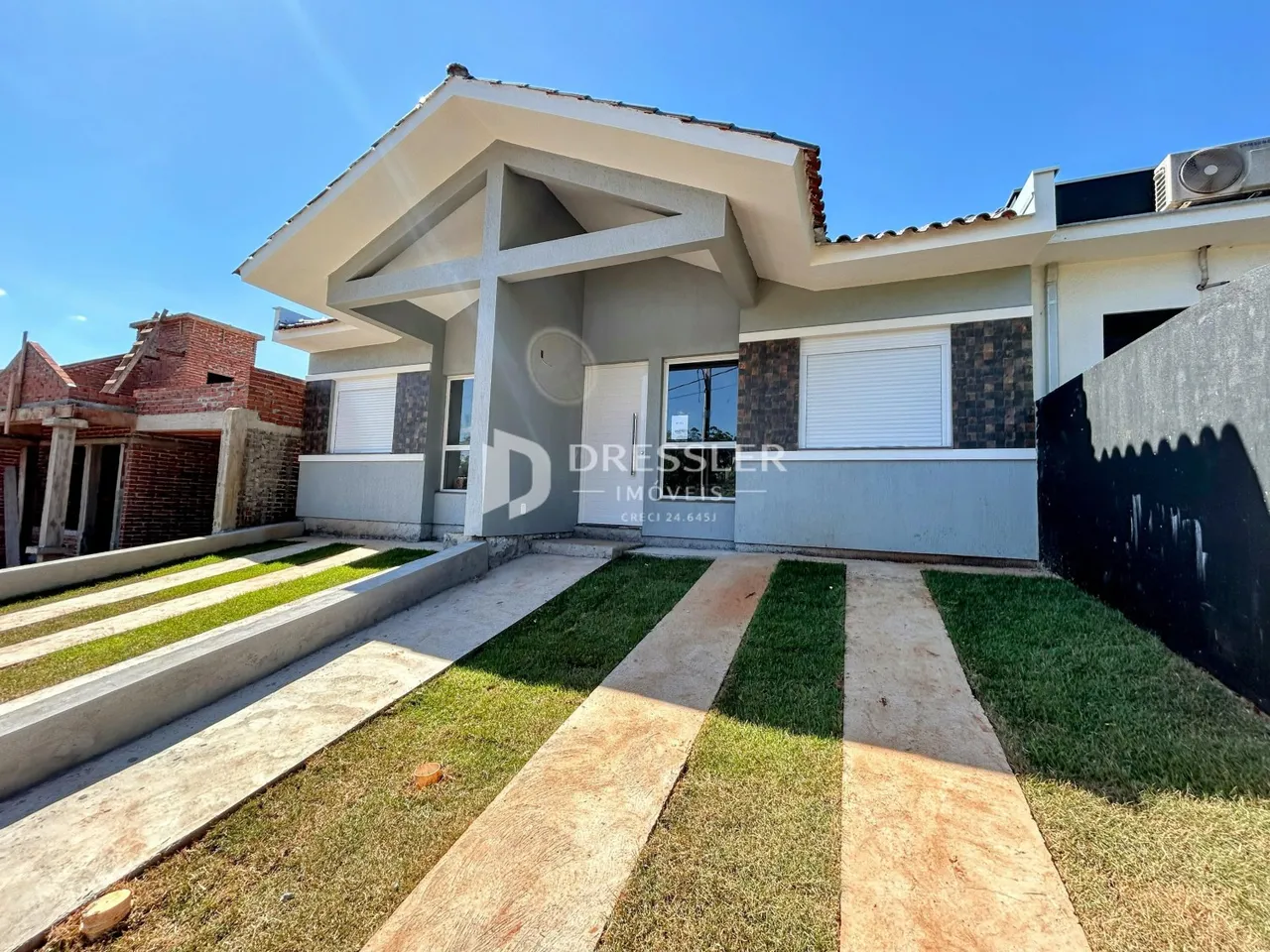 Fachada de uma casa em Lajeado, Brasil, com jardim frontal e calçada.