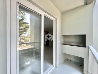 Vista de uma porta de vidro que leva a uma área externa e um corredor interno.