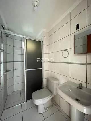 Foto de um banheiro com revestimento de azulejos brancos.