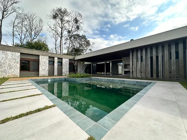 Foto da piscina e da fachada de uma residência em Lajeado, Brasil.