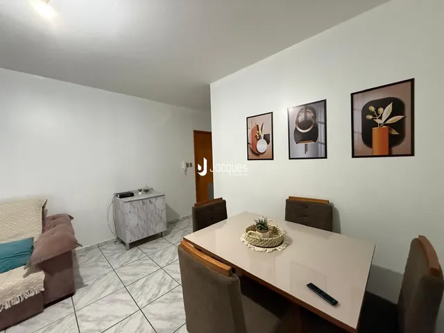 Ambiente interno de uma sala de estar com piso de cerâmica e decoração de parede.