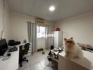 Um quarto com cama, escrivaninha e armário branco é mostrado na propriedade.