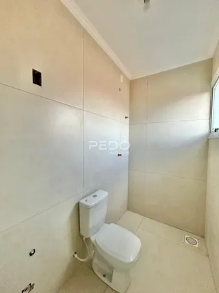 Foto de um banheiro interno com paredes revestidas de azulejo branco.