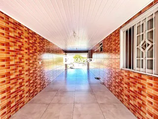 Corredor interno com paredes de tijolos aparentes e piso de cerâmica.