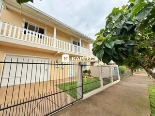 Foto da fachada de uma casa em Lajeado, Brasil, mostrando a varanda e o muro frontal.