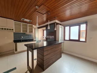 Vista de uma cozinha moderna com teto de madeira e ilha.