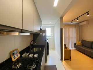 Vista da cozinha moderna com armários brancos e bancada escura.