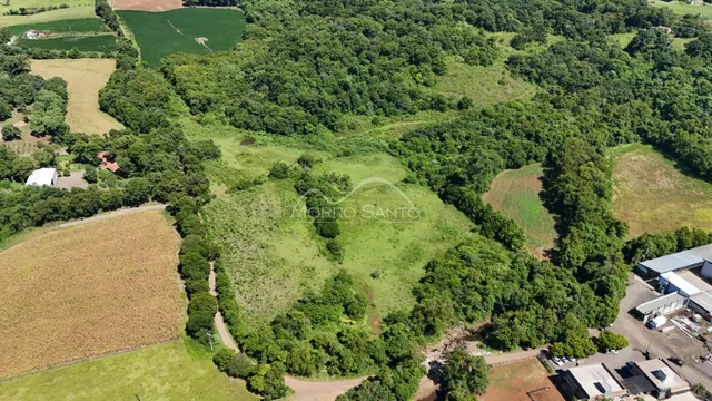 Vista aérea de uma propriedade rural com vegetação densa e áreas abertas.