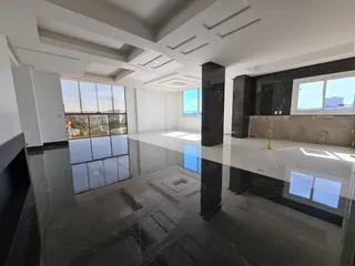 Sala de estar ampla com piso de mármore polido e grandes janelas.