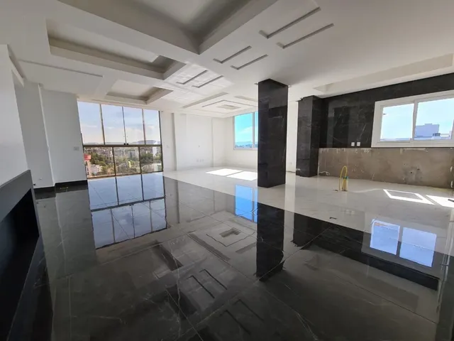 Sala de estar ampla com piso de mármore polido e grandes janelas.
