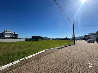Vista externa de um terreno com gramado e calçada.