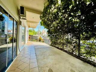 Vista externa do imóvel mostrando um caminho pavimentado e vegetação densa.