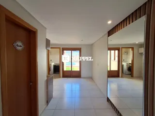 Hallway com piso de cerâmica e portas de madeira clara.