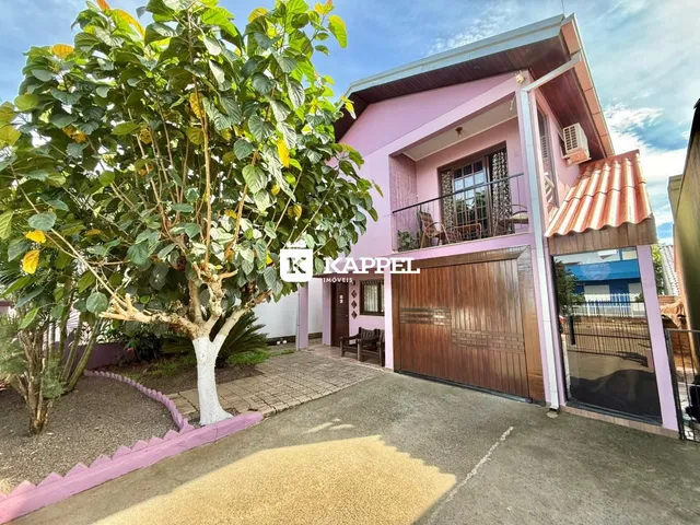 Fachada de uma casa rosa em Lajeado, com garagem e jardim na frente.