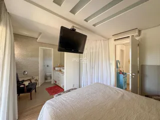 Quarto com cama e televisão em um apartamento no Brasil.