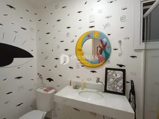 Foto de um banheiro decorado com papel de parede de olhos e um espelho redondo.