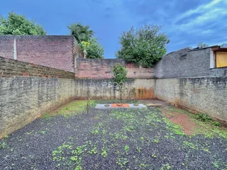 Vista externa de um terreno com paredes de tijolo e concreto no Brasil.
