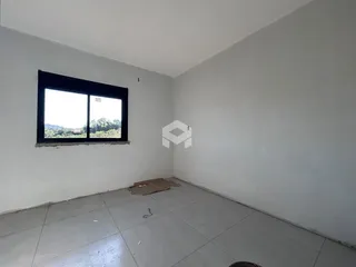 Vista interna de um cômodo com parede branca e piso de cerâmica.