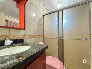 Foto de um banheiro com bancada de granito e revestimento de cerâmica.