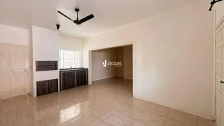 Sala de uma residência com piso de cerâmica e portas de madeira.