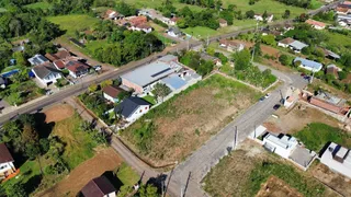 Vista aérea de uma propriedade com estruturas e áreas verdes.