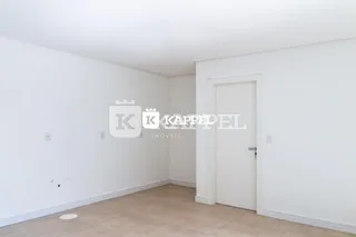 Foto de um ambiente interno com paredes brancas e piso claro.
