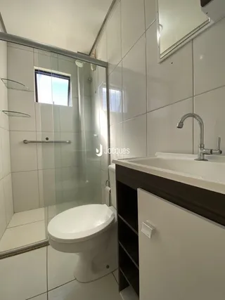 Foto de um banheiro com azulejos brancos e box de vidro.